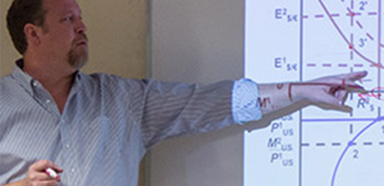 instructor pointing to a graphic on a board